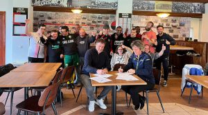 Sandra van Koningsbrugge (directeur Stichting Sportbelang Gehandicapten) en Ron Jansen (voorzitter HVV Laakkwartier) ondertekenen onder toeziend van de spelers van het G-Team het convenant.
